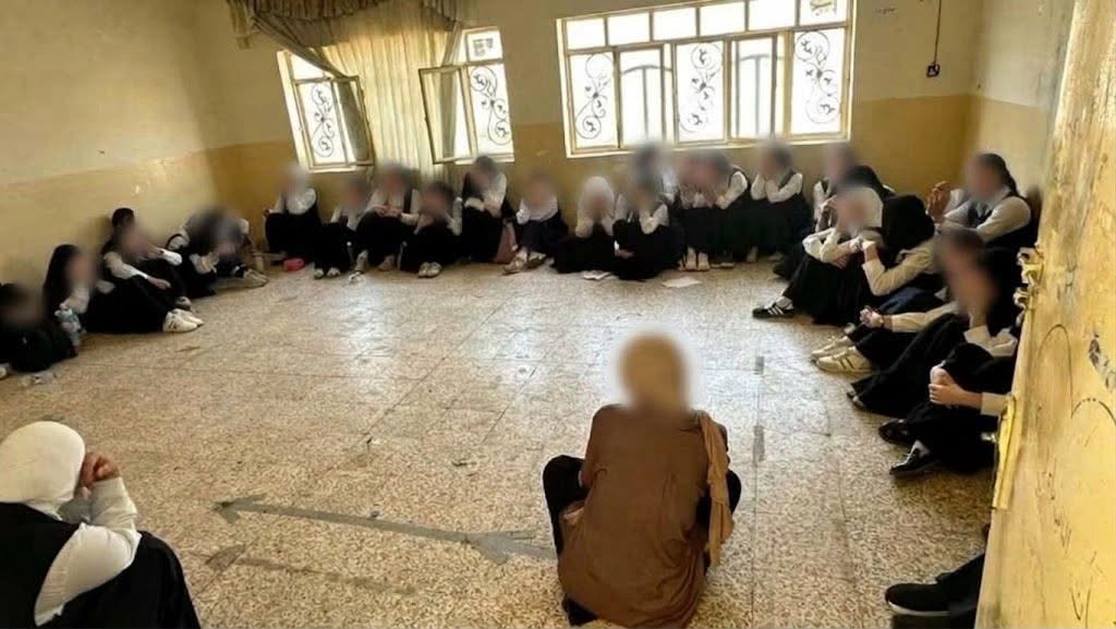 لە قوتابخانەیەکی دیوانییە قوتابیان لەسەر زەوی دادەنیشن